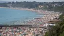 Kerumunan pengunjung berkumpul di pantai untuk menikmati hari terpanas tahun ini di Bournemouth, Kamis (25/6/2020). Para pejabat di Inggris selatan menyatakan keadaan darurat setelah ribuan orang berbondong-bondong menyambangi pantai setempat. (Andrew Matthews/PA via AP)