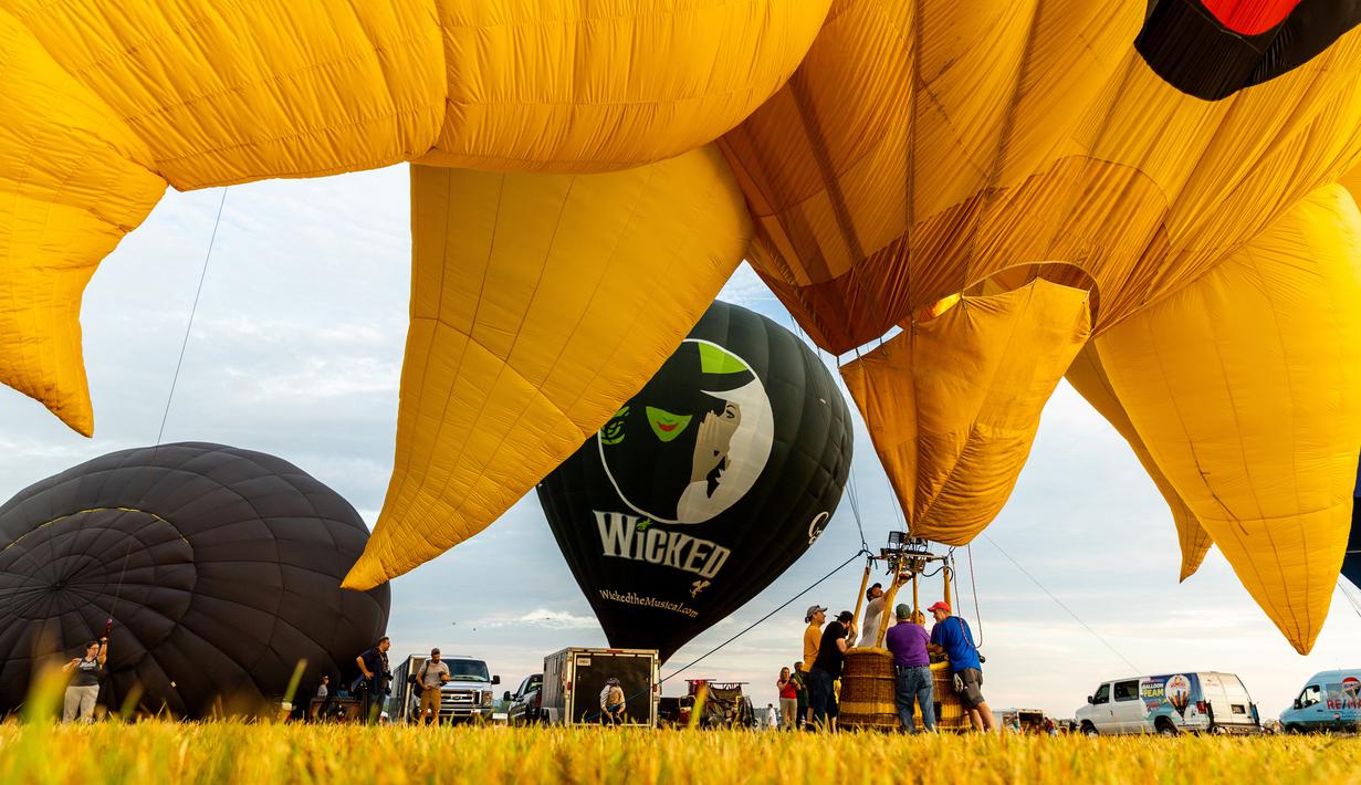 Kru memompa balon udara pada New Jersey Lottery Festival of Ballooning di Bandara Solberg, Readington, New Jersey, Amerika Serikat, 29 Juli 2022. Festival yang berlangsung hingga 31 Juli ini akan menampilkan sebanyak 100 balon. (AP Photo/Julia Nikhinson)