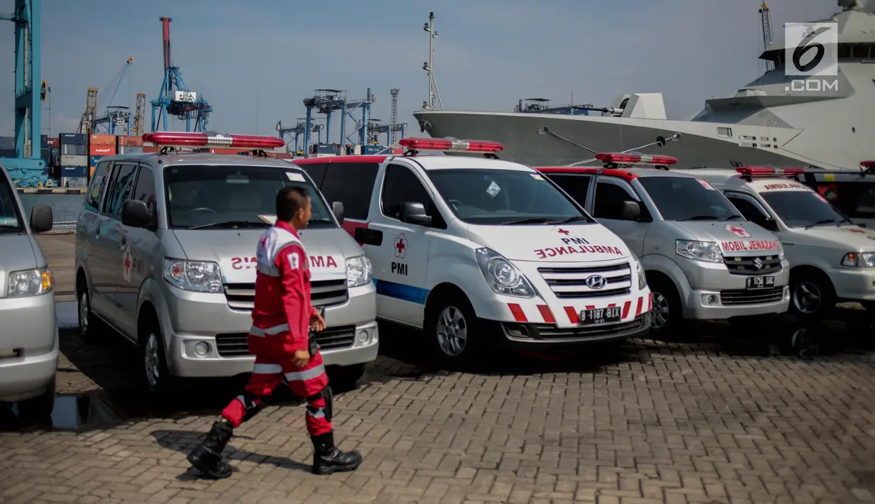 Petugas PMI melintas dekat deretan ambulans yang disiagakan di Posko Evakuasi, Tanjung Priok, Jakarta, Senin (29/10). Posko itu menjadi tempat transit korban jatuhnya pesawat Lion Air JT610 di laut utara Karawang, Jawa Barat. (Liputan6.com/Faizal Fanani)