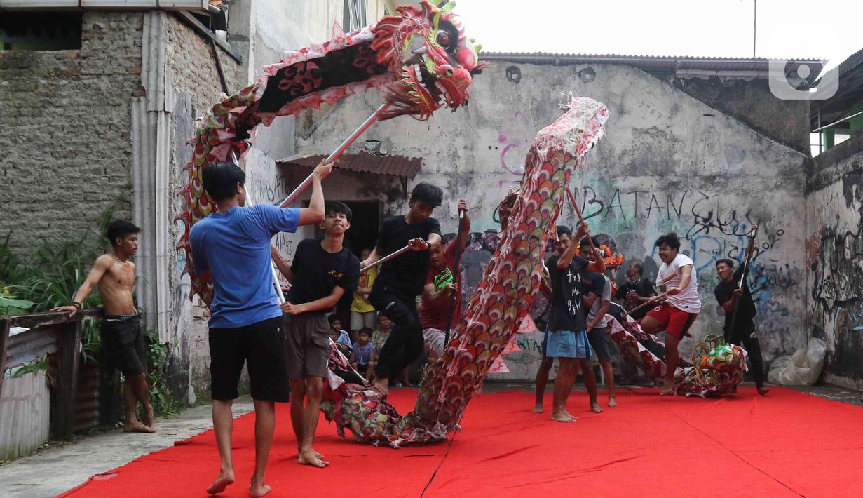 Pemain dari kelompok barongsai Naga Merah Putih Bogor melakukan latihan dengan Liong di kawasan Babakan Pasar, Kota Bogor, Jawa Barat, Rabu (11/1/2023). Latihan tersebut  untuk mempersiapkan penampilan menyambut Tahun Baru Imlek. (Liputan6.com/Herman Zakharia)