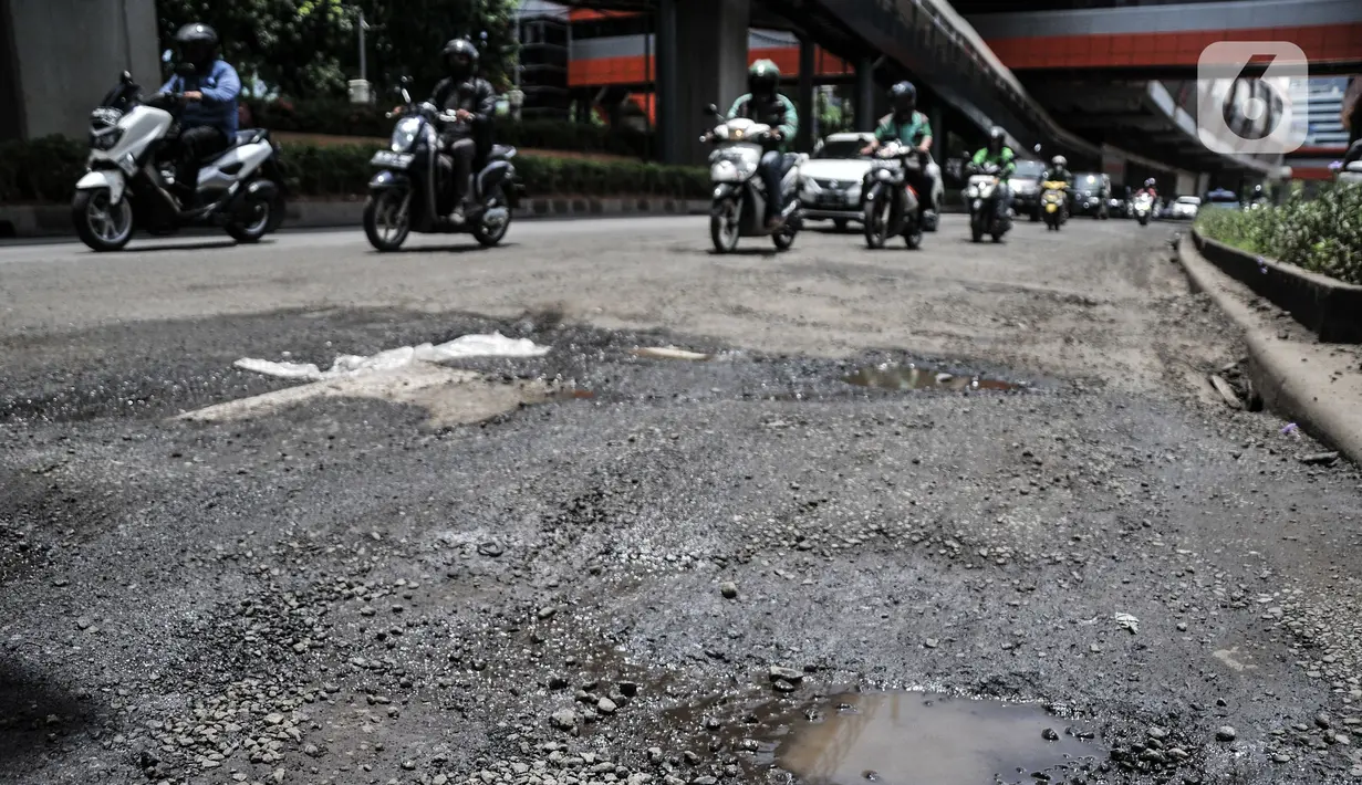 Kendaraan menghindari jalan rusak dan berlubang saat melintas di Jalan HR Rasuna Said, Kuningan, Jakarta Selatan, Senin (24/10/2022). Kondisi jalan menjadi lebih parah saat turun hujan sehingga menyebabkan genangan yang menutupi lubang. (merdeka.com/Iqbal S. Nugroho)