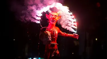Kembang api meledak di patung setan yang memegang kepala Presiden AS Donald Trump saat perayaan pembakaran Yudas di Mexico City, Meksiko (15/4). Perayaan ini adalah bagian dari ritual paskah yang biasa digelar di Meksiko. (AP Photo/Rebecca Blackwell)