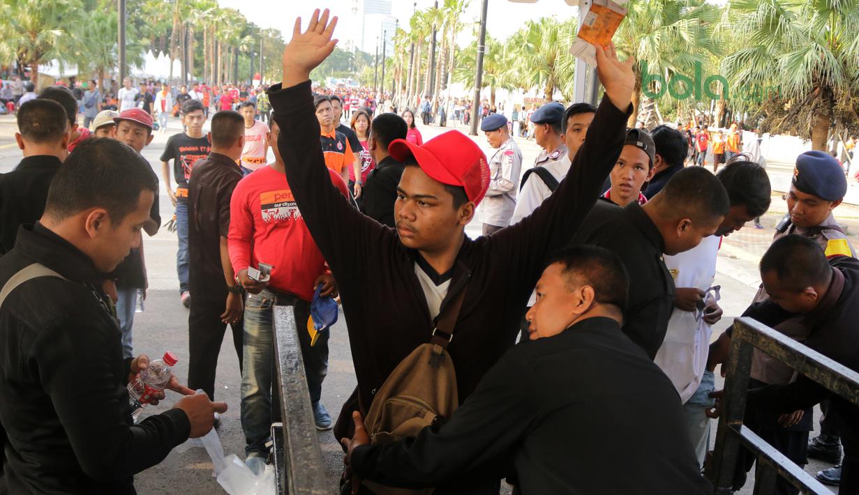Aksi The Jakmnia mengangkat tangan saat jalani pemeriksaan sebelum menonton laga Piala AFC 2018 antara Persija jakarta vs Song Lam Nghe An di Stadion Utama GBK, Rabu (14/3/2018). Panpel menjual sekitar 65.000 lembar tiket. (Bola.com/Surya Bima Mahendarta)