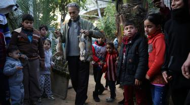 Pemilik kebun binatang Fathi Jumaa membawa mayat empat anak singa sebelum dikubur di kebun binatangnya di kamp pengungsi Rafah, Gaza (18/1). Fathi mengatakan ia menutupi sangkar singa-singa dengan selimut jelang badai musim dingin. (AP Photo/Adel Hana)