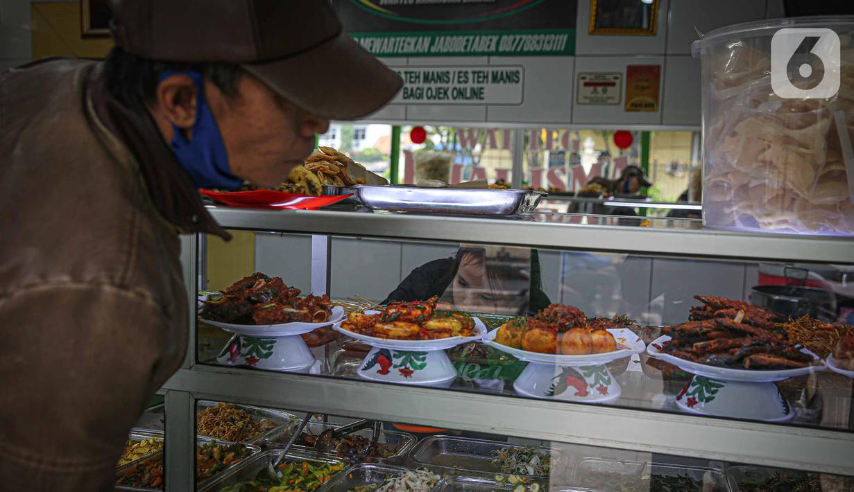 Warga memesan makanan di rumah makan Warteg Bahari, Jakarta, Rabu (1/12/2021). Dalam salinan Inmendagri tersebut juga tertulis waktu makan maksimal selama 60 menit. (Liputan6.com/Faizal Fanani)