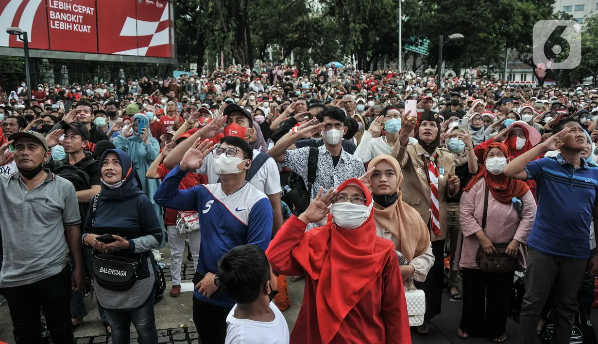 Warga memberikan hormat saat pengibaran bendera Merah Putih dalam Upacara HUT ke-77 Republik Indonesia yang disaksikan dari Taman Aspirasi Monumen Nasional (Monas), Rabu (17/8/2022). Setelah sempat ditiadakan selama 2 tahun akibat pandemi Covid-19, Upacara Peringatan Kemerdekaan Republik Indonesia disambut antusias warga dari berbagai daerah yang berdatangan untuk mengikuti meski hanya dari luar Istana Negara. (merdeka.com/Iqbal S Nugroho)