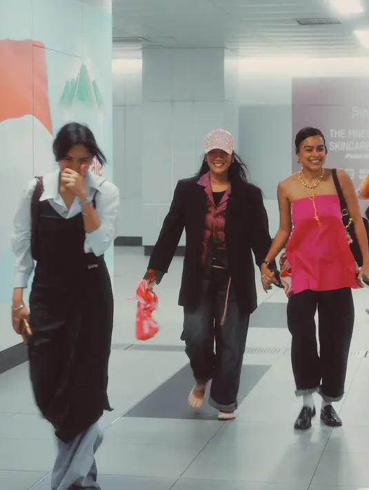 Pada foto kedua, Tara kembali menunjukkan sisi preppy-nya dengan kombinasi kemeja putih, vest abu-abu, dan rok panjang motif garis. Look ini memberikan kesan vintage namun tetap modern, sangat cocok dengan kepribadiannya yang berkarakter kuat. Ditambah dengan sandal minimalis dan tas besar berwarna coklat, gaya Tara tampak nyaman namun tetap fashionable. [@taabasro].