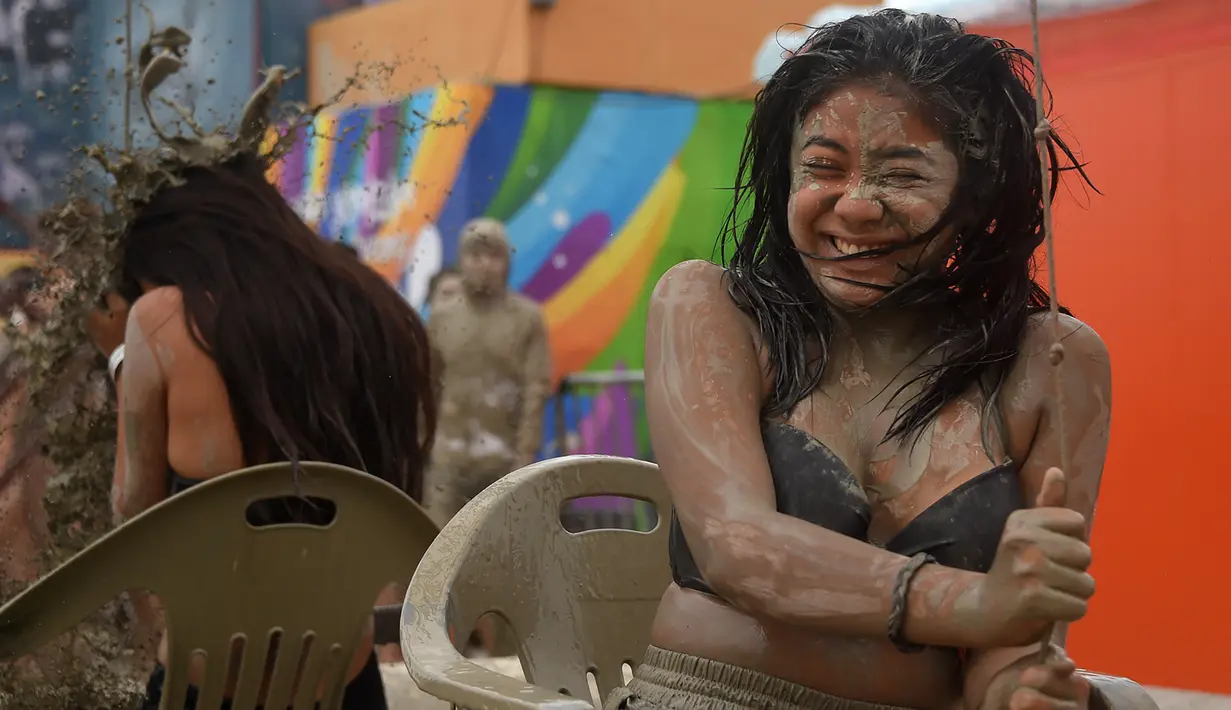 Wisatawan bermain di kolam lumpur selama Boryeong Mud Festival atau Festival Lumpur Boryeong di pantai Daecheon, Korea Selatan, Sabtu (20/7/2019). Festival ini dikenal sebagai festival paling populer di Korea Selatan dan berhasil mengundang ribuan turis dari seluruh penjuru dunia. (Minji SUH/AFP)