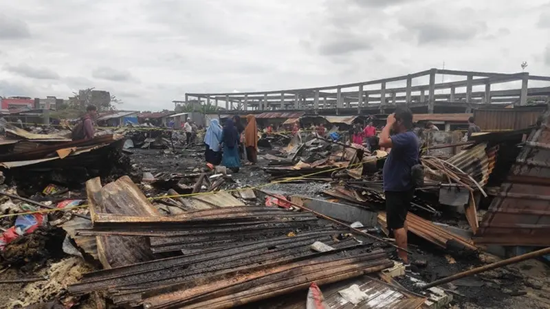 Salah satu pedagang di Pasar Cik Puan Pekanbaru melihat bekas kiosnya yang terbakar.