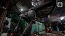 Pekerja membelah Koperasi Angkutan Jakarta (Kopaja) yang akan diremajakan di kawasan Meruya, Jakarta Barat, Rabu (27/1/2021). Kopaja yang tak lagi digunakan tersebut dihancurkan untuk dijual secara kiloan ke penjual besi tua. (Liputan6.com/Johan Tallo)