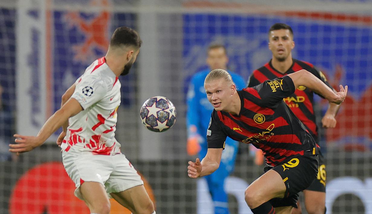 Pemain Manchester City, Erling Haaland (kanan) berebut bola dengan bek RB Leipzig, Josko Gvardiol dalam pertandingan leg pertama babak 16 besar Liga Champions 2022/2023 antara RB Leipzig melawan Manchester City yang berlangsung di Red Bull Arena, Kamis (23/2/2023). (AFP/Odd Andersen)