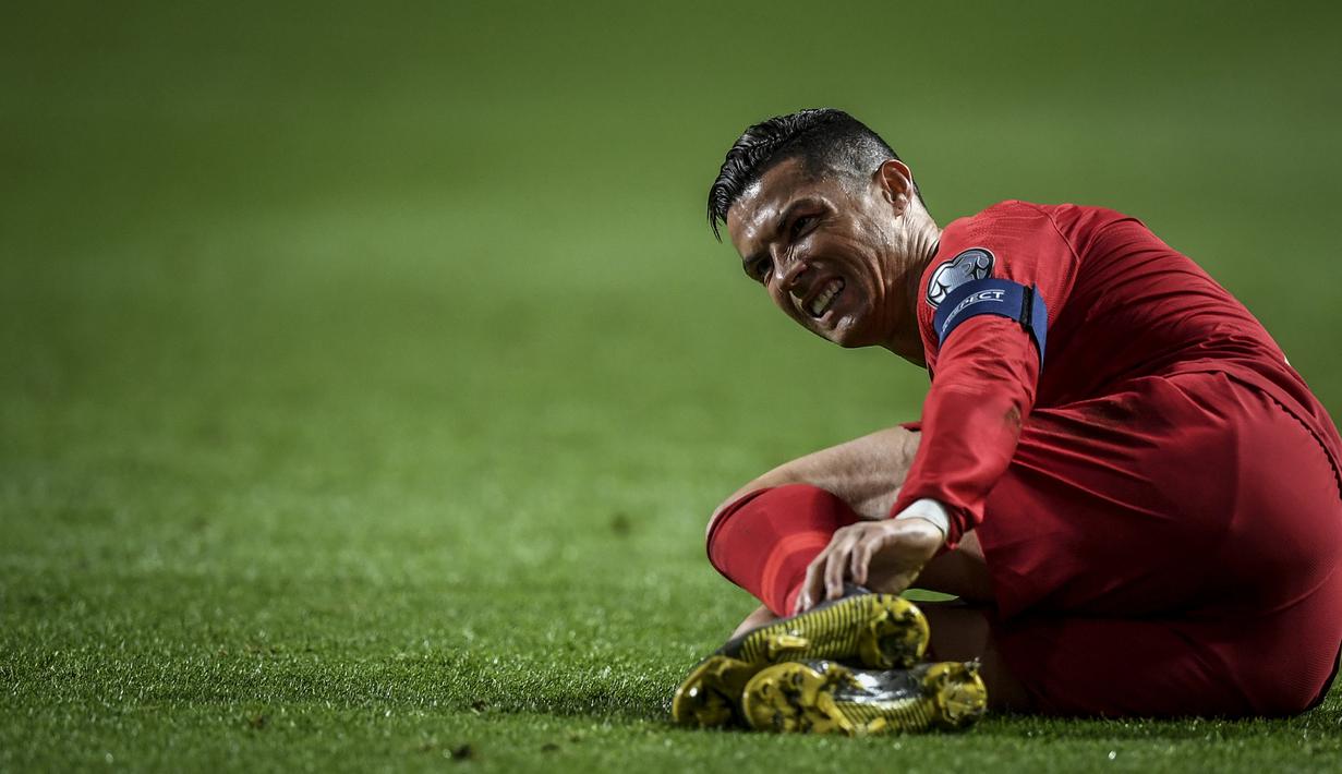 Gelandang Portugal, Cristiano Ronaldo, kesakitan saat melawan Ukraina pada laga Kualifikasi Piala Eropa 2020 di Stadion Luz, Lisbon, Jumat (22/3). Kedua negara bermain imbang 0-0. (AFP/Patricia De Melo Moreira)