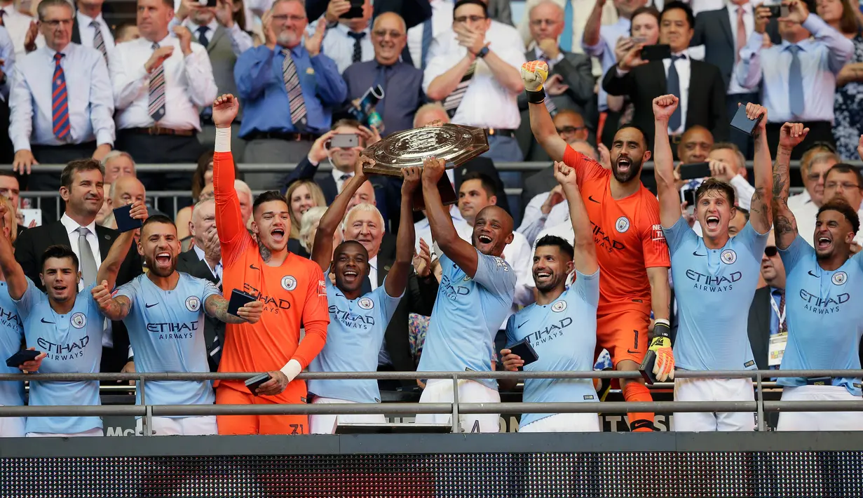 Pemain Manchester City mengangkat piala usai mengalahkan Chelsea dalam Community Shield di Wembley, London, Inggris, Minggu (5/8). Sergio Aguero mencetak dua gol ke gawang Chelsea. (AP Photo/Tim Ireland)