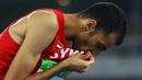 Atlet lompat tinggi Suriah, Majd Eddin Ghazal, mencium bendera negaranya usai tampil pada Olimpiade 2016 di Rio de Janeiro, Brasil, Sabtu (20/8/2016). Konflik dalam negeri tak menyurutkan semangat para atlet dari Suriah. (Reuters/Kai Pfaffenbach)