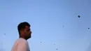 Pria Irak melihat membeli permainan tradisional layang-layang yang terbang dilangit selama bulan Ramadan di Kerbala pada 12 Mei 2019. Bermain layang-layang merupakan salah satu cara muslim Irak untuk mengisi waktu sambil menunggu saat berbuka puasa (ngabuburit). (REUTERS/Abdullah Dhiaa Al-Deen)