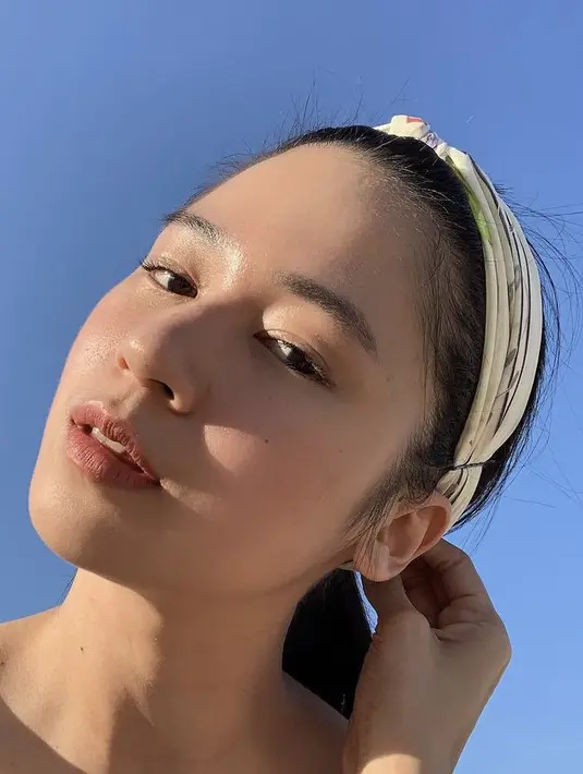 Hanya terlihat mengenakan lipstik coral matte, Laura pun tampil memamerkan kecantikan effortless. Ia pun tampil dengan bando di atas rambut yang diikat. (@laurabas)