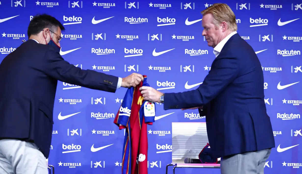 Presiden Barcelona, Josep Maria Bartomeu, memberikan jersey kepada pelatih baru Barcelona, Ronald Koeman, saat acara perkenalan di Barcelona, Rabu (20/8/2020).  Koeman resmi menjadi pelatih Barcelona untuk dua tahun kedepan. (AP/Joan Monfort)