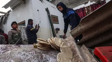 Seorang pemuda menyelamatkan roti dari sebuah rumah yang rusak, setelah pengeboman Israel di Rafah, Jalur Gaza selatan pada 25 Februari 2024. (SAID KHATIB/AFP)