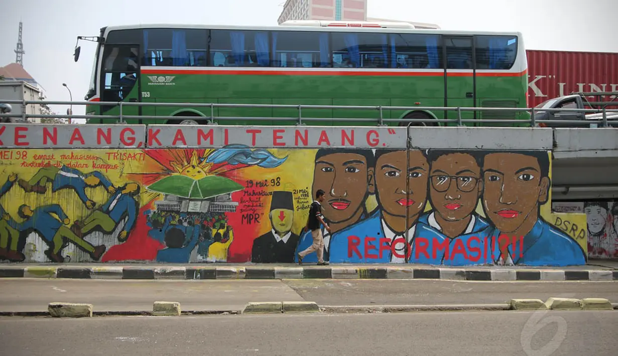 Seorang warga melintas di depan mural "Tragedi Trisakti dan Mei 1998" di Jakarta, Selasa (14/5/14). (Liputan6.com/Faizal Fanani)