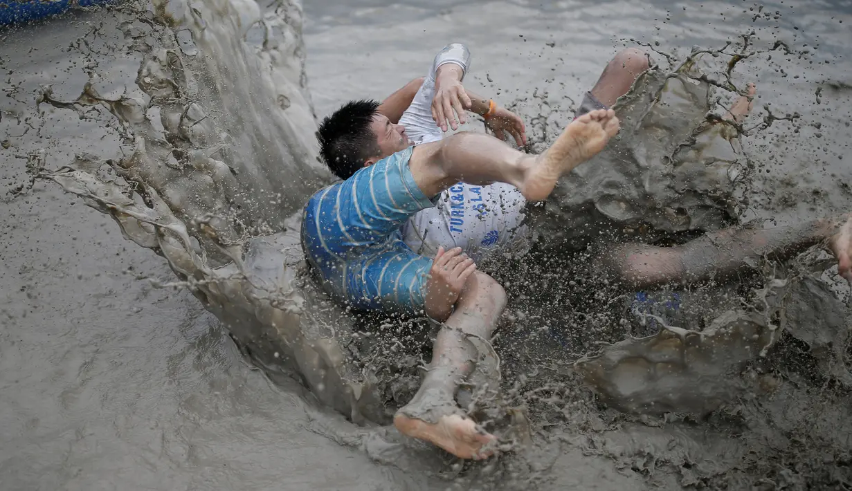 Turis bergulat di kubangan lumpur saat mengikuti Festival lumpur Boryeong di pantai Daecheon, Boryeong, Korea Selatan, (15/7). Festival ini digelar setiap tahun sekali pada bulan Juli. ( REUTERS/Kim Hong-Ji)
