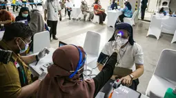 Petugas kesehatan memeriksa suhu tubuh seorang pemuka agama sebelum menjalani Vaksinasi COVID-19 di Mesjid Istiqlal, Jakarta, Selasa (23/2/2021). Para pemuka agama itu berasal dari seluruh wilayah di Jakarta. vaksinasi akan berlangsung selama dua hari. (Liputan6.com/Faizal Fanani)