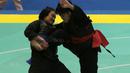 Aksi pesilat Laos, Olahthai Sounthavong beursaha membanting Octaviani Nirmalasari (kanan) pada semifinal Test Event Pencak Silat 2018 di Padepokan Silat TMII, Jakarta, (12/2/2018). Oktaviani menang 5-0. (Bola.com/Nick Hanoatubun)