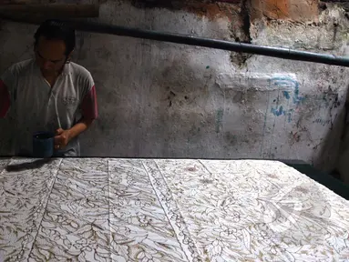 Pengrajin batik tulis sedang melakukan tahap pewarnaan motif batik di Kampung batik, Jetis, Sidoarjo, Senin (31/03/2015). Produksi Batik Kota Sidoarjo ini sejak tahun 1960-an hingga saat ini masih tetap bertahan. (Liputan6.com/Andrian M Tunay)