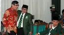 Ketua Umum PKB Muhaimin Iskandar (kedua kiri) memeluk Menkumham Yasonna Laoly (kiri) disaksikan Sekjen PKB Abdul Kadir Karding dalam peringatan hari lahir ke-18 Partai Kebangkitan Bangsa di DPP PKB Jakarta, Sabtu (23/7). (Liputan6.com/Helmi Afandi)