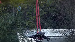 Crane mengevakuasi bangkai helikopter dari lokasi kecelakaan yang menewaskan pemilik Leicester City Vichai Srivaddhanaprabha di Leicester, Inggris, Kamis (1/11). Selain Vichai, 4 orang lainnya juga tewas dalam kecelakaan tersebut. (Aaron Chown/PA via AP)