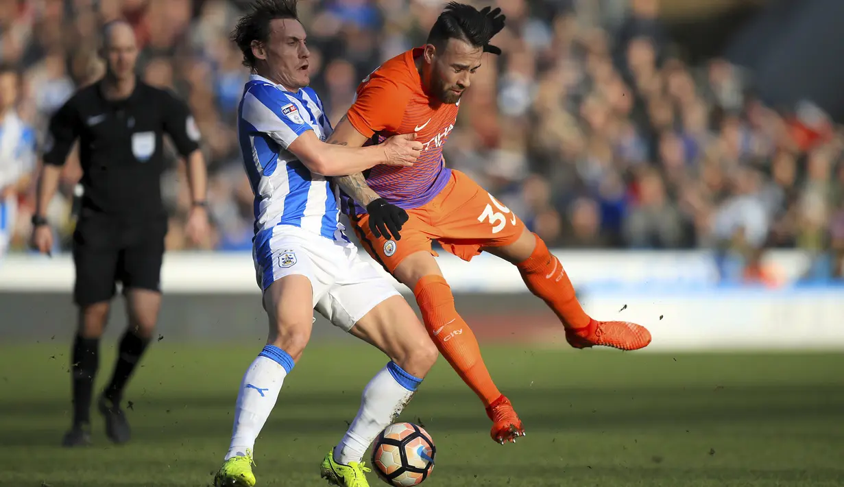 Pemain Huddersfield Town, Dean Whitehead berebut bola dengan pemain Manchester City, Nicolas Otamendi (kanan) pada putran kelima Piala FA di John Smith's Stadium, Huddersfield, (18/2/2017). (Mike Egerton/PA via AP)