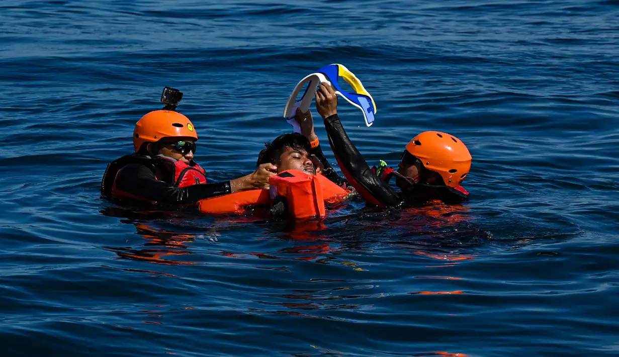 Anggota Badan Pencarian dan Pertolongan Nasional (Basarnas) menyelamatkan seorang relawan saat latihan bersama di perairan lepas pantai Banda Aceh pada 31 Agustus 2024. (CHAIDEER MAHYUDDIN/AFP)