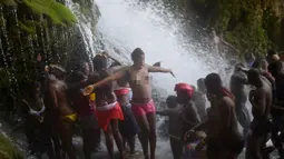Sejumlah wanita bertelanjang dada mandi di bawah air terjun di Saut d' Eau, Haiti (15/7). Ritual ini juga dipercaya untuk menghormati Bunda Maria dari Gunung Karamel. (AFP Photo/Hektor Retamal)