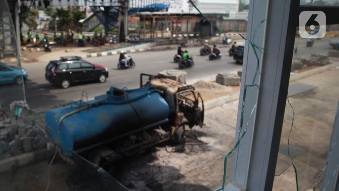 Kondisi mobil proyek yang hangus terbakar saat unjuk rasa menolak pengesahan Undang-Undang Cipta Kerja di kawasan Senen, Jakarta, Jumat (9/10/2020). Unjuk rasa tersebut berakhir ricuh dan mengakibatkan sejumlah fasilitas umum rusak. (Liputan6.com/Angga Yuniar)