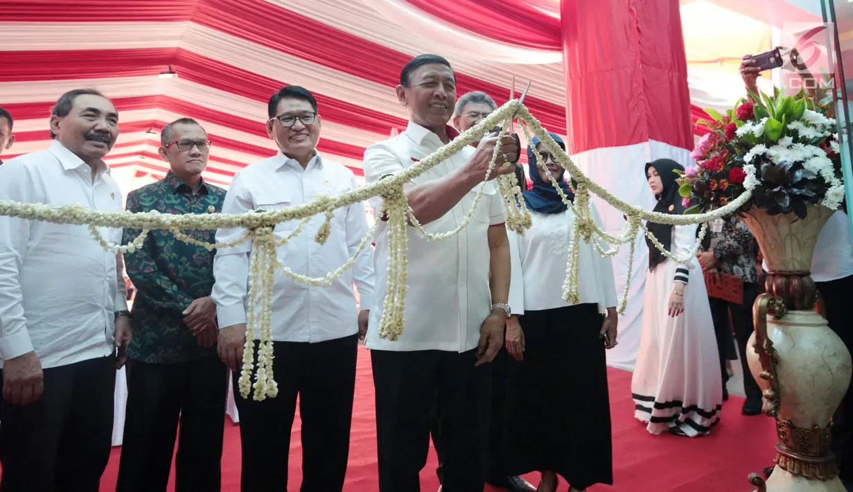 Menko Polhukam Wiranto didampingi Ketua LPSK Abdul Haris Semendawai menggunting pita saat memberi kompensasi kepada sejumlah perwakilan korban terorisme di Kantor LPSK, Jakarta, Kamis (6/9). (Liputan6.com/Faizal Fanani)
