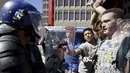 Polisi bentrok dengan pelajar di luar Parlemen Afrika Selatan di Cape Town, Rabu (21/10). Polisi anti huru hara menembakkan gas airmata kepada ratusan pelajar yang berdemonstrasi menentang rencana kenaikan uang sekolah. (REUTERS/Mark Wessels)