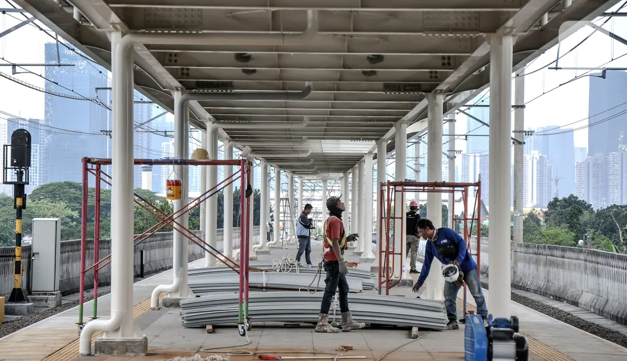 Pekerja menyelesaikan pemasangan atap peron Stasiun Matraman, Jakarta Timur, Kamis (23/12/2021). Pembangunan Stasiun Matraman memasuki pemasangan atap peron, sementara fasilitas pendukung seperti eskalator, sarana umum, dan rambu sudah siap digunakan. (merdeka.com/Iqbal S. Nugroho)