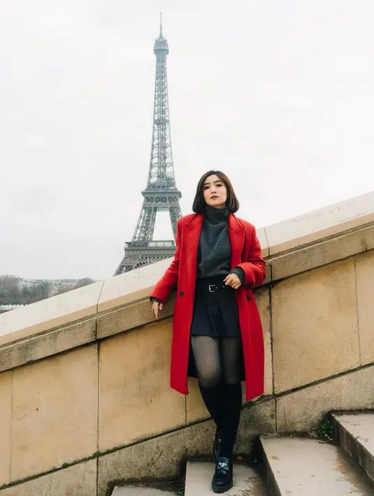 Febby Rastanty tengah menikmati momen liburan di Paris. Di potret ini, ia tampil stylish dengan coat merah, turtleneck top, shorts dan stocking hitam. [@febbyrastanty]