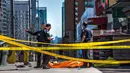 Petugas polisi berdiri dekat salah satu jasad akibat serangan mobil di Toronto bagian utara, Kanada, Senin (23/4). Serangan terjadi ketika sebuah van bergerak ke arah pejalan kaki di jalanan sibuk Toronto. (Aaron Vincent Elkaim/The Canadian Press via AP)