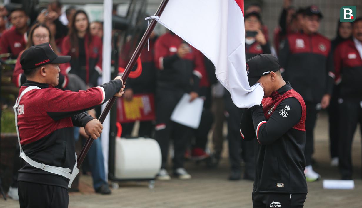 Perwakilan atlet Indonesia mencium mencium bendera Merah Putih saat pengukuhkan kontingen Indonesia untuk SEA Games 2023 Kamboja yang berlangsung di Kantor Kemenpora, Senayan, Jakarta, Selasa (02/05/2023). Sebanyak 599 atlet akan tampil dalam 31 cabang olahraga. (Bola.com/Bagaskara Lazuardi)