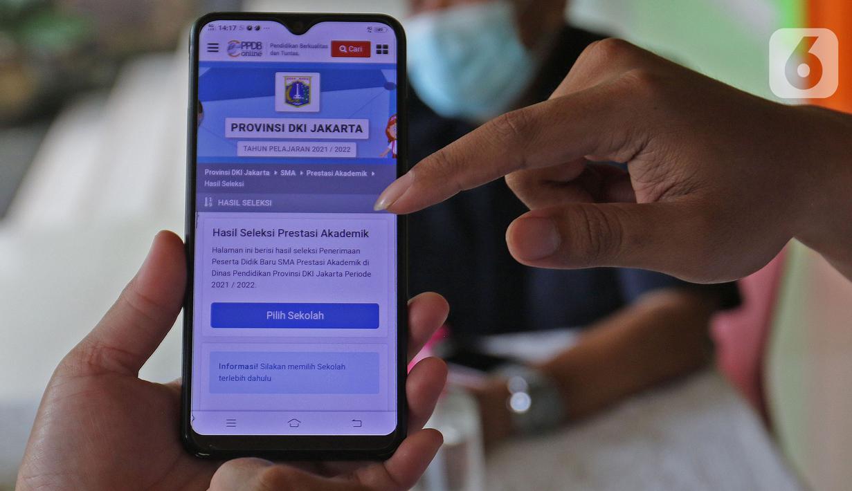Guru menjelaskan informasi pengajuan akun untuk mengikuti proses Penerimaan Peserta Didik Baru (PPDB) Tahun Pelajaran 2021/2022 di SMA Negeri 87 Jakarta, Senin (7/6/2021).  Proses PPDB DKI Jakarta yang mulai dibuka sejak hari ini, Senin (7/6). (Liputan6.com/Herman Zakharia)