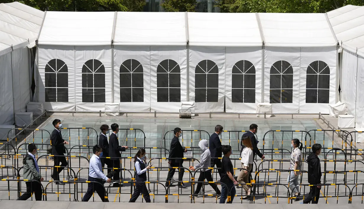 <p>Warga berbaris untuk pengujian massal COVID-19 dekat tenda yang didirikan di sebuah plaza di Distrik Haidian, Beijing, China, Selasa (26/4/2022). Beijing memberlakukan pengujian massal dan menutup akses ke lingkungan karena berupaya menahan wabah COVID-19 baru. (AP Photo/Ng Han Guan)</p>