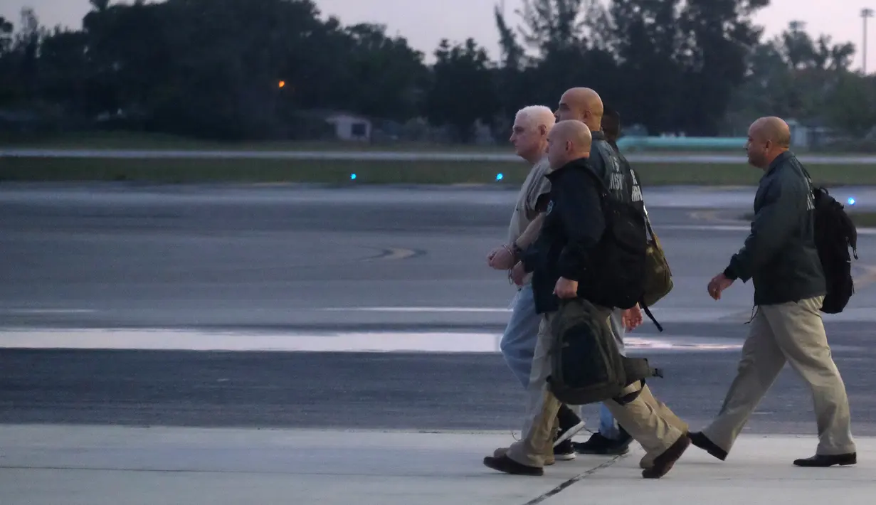Mantan presiden Panama, Ricardo Martinelli dikawal Marshals AS saat diekstradisi dari Bandara Opa Locka, dekat Miami, Florida, AS, Senin (11/6). Martinelli didakwa telah menggelapkan lebih dari USD 10 juta dana pemerintah. (Gaston De Cardenas/AFP)
