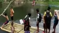 Menyeberang sungai dengan rakit yang memiliki resiko tinggi terpaksa dilakukan siswa sejak Jembatan Sangkurio ambruk.