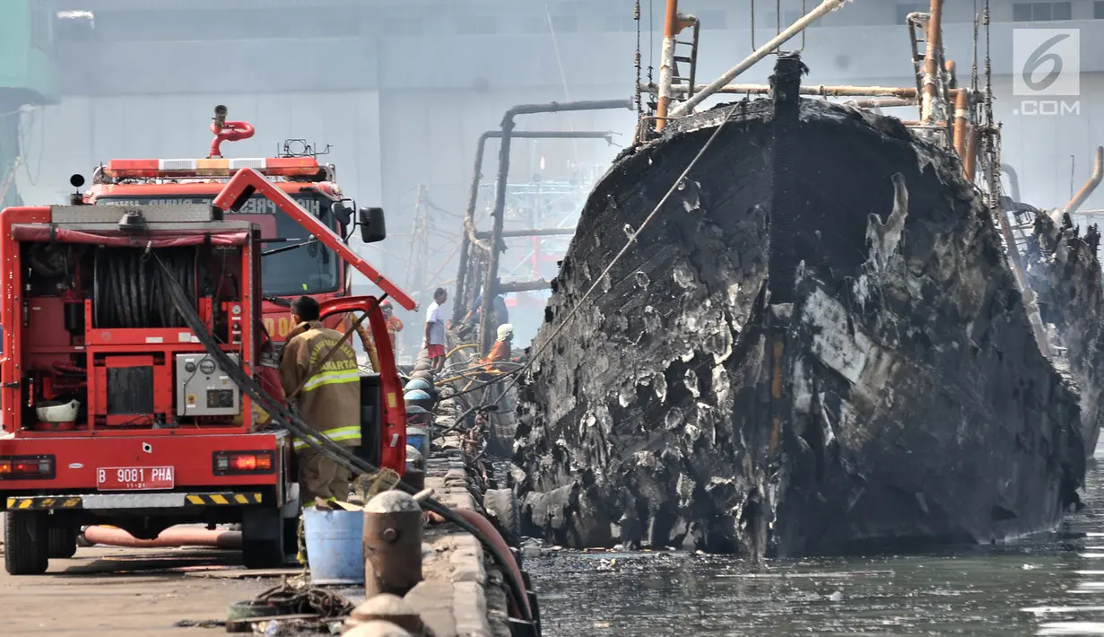 Petugas pemadam kebakaran melakukan pendinginan kapal yang ludes dilalap api di Pelabuhan Muara Baru, Jakarta, Minggu (24/2). Hingga kini belum diketahui penyebab pasti kebakaran tersebut. (Merdeka.com/Iqbal Nugroho)
