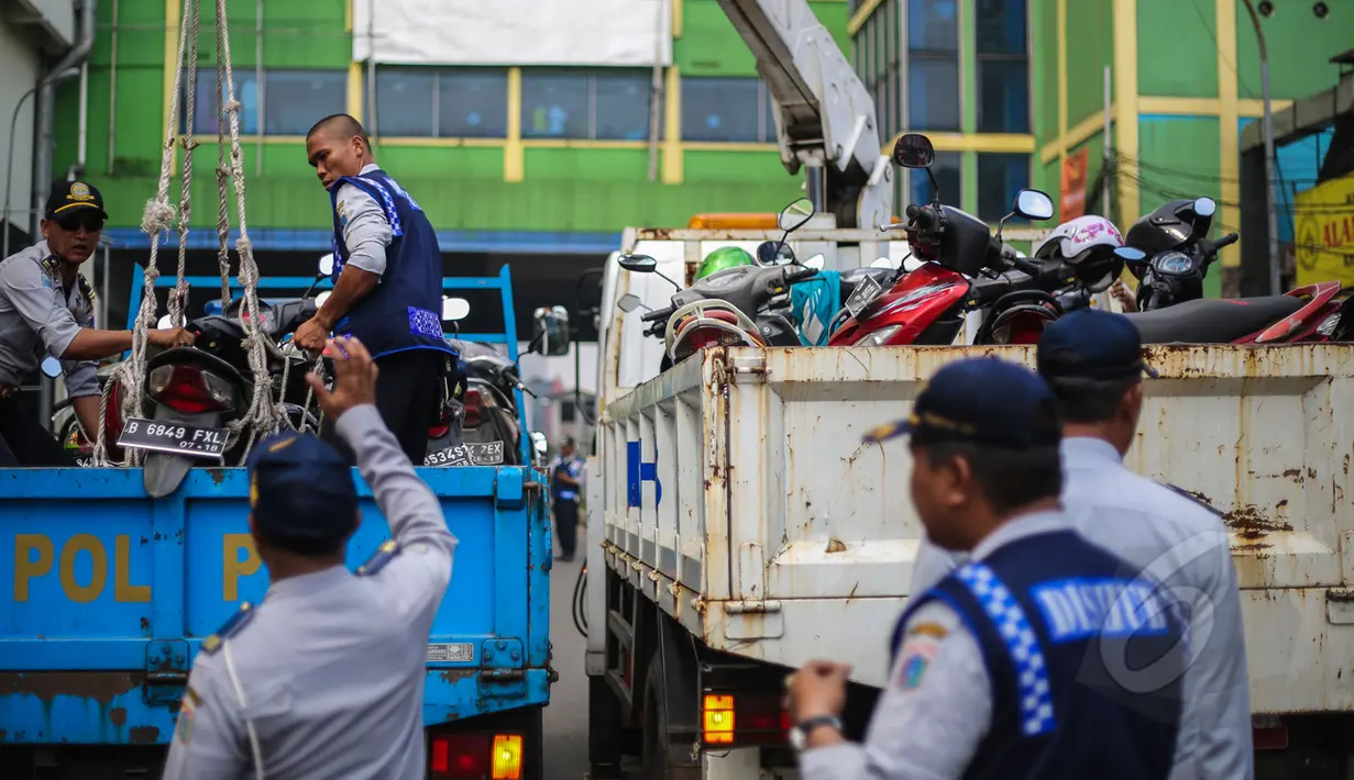 Petugas Dinas Perhubungan merazia parkir liar motor dengan menggunakan jaring di kawasan Pasar Tanah Abang, Jakarta, Kamis (16/4/2015). Razia dilakukan untuk menciptakan kawasan yang tertib serta nyaman di kawasan Tanah Abang. (Liputan6.com/Faizal Fanani)