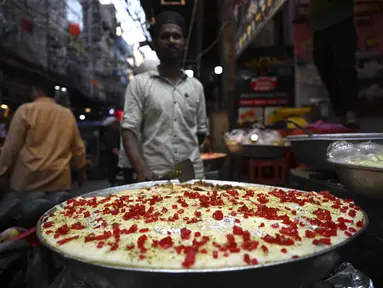 Dalam gambar pada 3 April 2022, penjaga toko yang menjual hidangan manis menunggu pelanggan di pasar pada hari pertama bulan suci Ramadhan di kawasan tua Delhi, India. Masjid dan jalan-jalan pasar penuh dengan keramaian malam, tergoda oleh aroma manisan manis untuk berbuka puasa. (Money SHARMA/AFP)