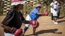 Para nenek berlatih tinju pada Boxing Gogos di Cosmo City, Johannesburg, Selasa (19/9/2017). Berkat latihan rutin yang dipimpin Claude Maphosa ini para lansia berhasil sembuh dari penyakit dan hidup lebih sehat. (AFP/Gulshan Khan) 