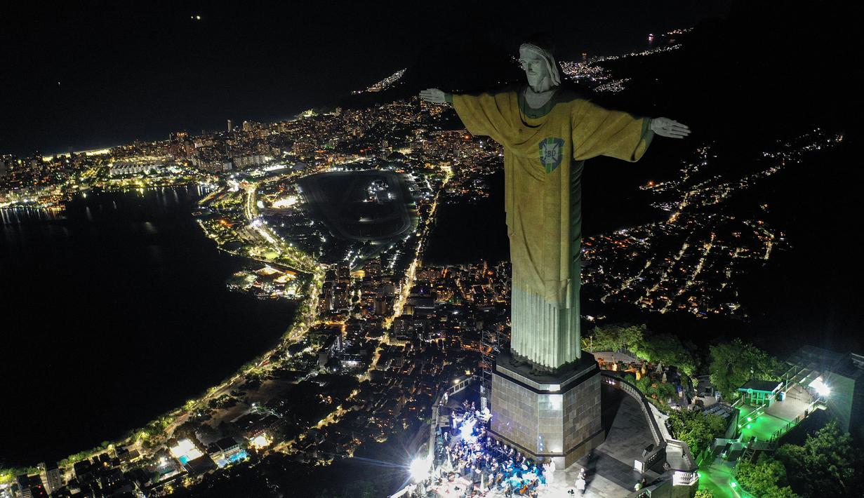 Pemandangan udara Patung Kristus Sang Penebus (Christ the Redeemer) di Rio de Janeiro, Brasil saat diterangi gambar jersey dari legenda sepak bola Brasil, Pele sebagai penghormatan atas satu tahung kematian sang pemain pada Jumat, 29 Desember 2023. (AFP/Mauro Pimentel)