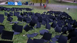 Orang-orang berjalan melewati beberapa ribu bendera kertas hitam yang didirikan oleh aktivis parpol oposisi Koalisi Demokrat, sebagai penghormatan untuk 6.000 orang yang meninggal selama Covid-19 di Bikas Park, Budapest, Hungaria, Rabu (9/12/2020). (ATTILA KISBENEDEK/AFP)