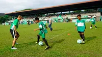 Kurniawan Dwi Yulianto (kiri) memberikan football clinic kepada anak-anak usia sekolah dasar di stadion Mini Universitas Sumut, Minggu (14/2/2016). Football clinic merupakan salah satu kegiatan di MILO Football Championship 2016. (Foto:Istimewa)